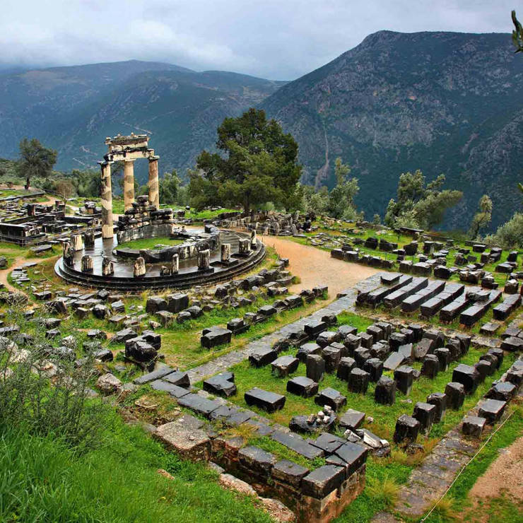 Ancient Tholos in Delphi set among green slopes