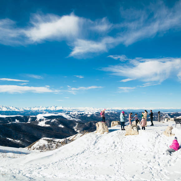 Visitors enjoying the snowy slopes and panoramic mountain views of Parnassos Ski Center