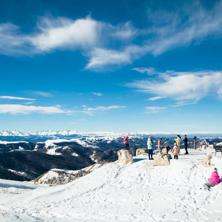 Visitors enjoying the snowy slopes and panoramic mountain views of Parnassos Ski Center