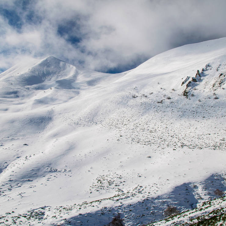 Snowy mountain peaks of Parnassos under dramatic clouds and bright winter light