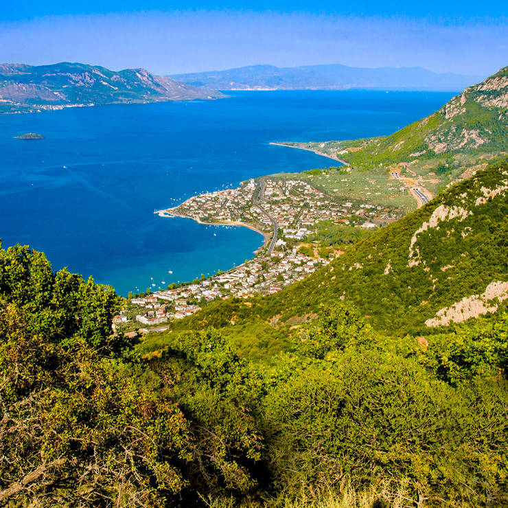 Aerial view of Kamena Vourla coastline with blue sea and lush green mountains