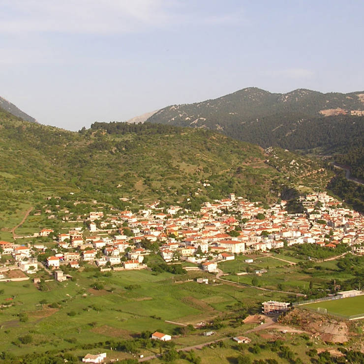 Green hillside village of Kyriaki, with traditional houses nestled among trees