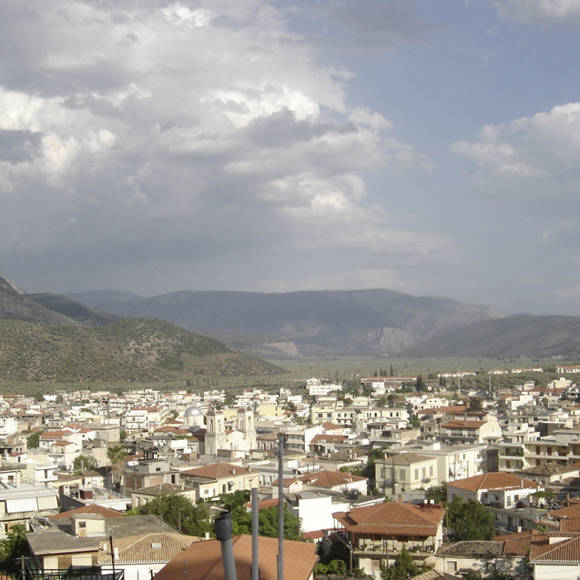 Panoramic view of Amfissa village with mountain backdrop and cloudy sky