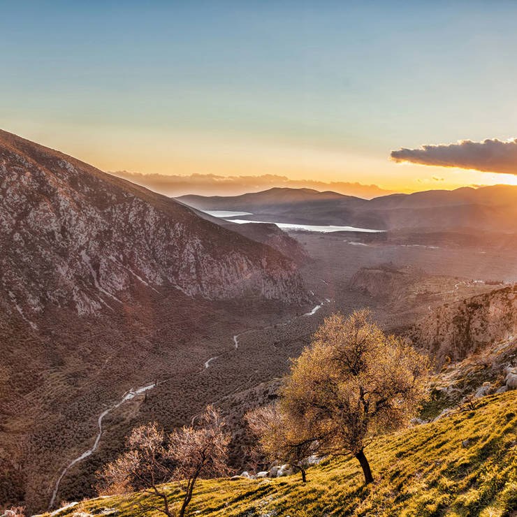 Sunset over the mountains and valley of Delphi with warm golden light and scenic views