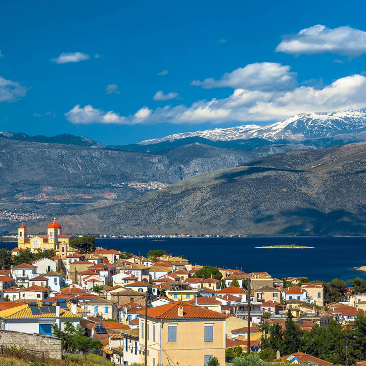 Coastal view of Galaxidi with colorful seaside houses and boats reflecting on calm waters