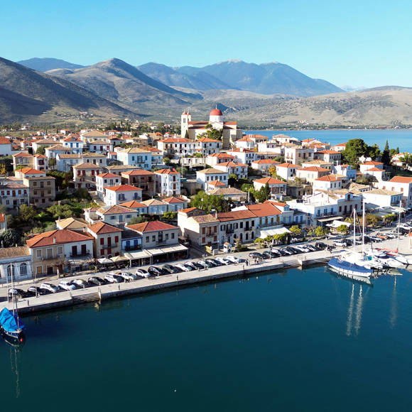 Aerial view of Galaxidi coastline harbor with mountains backdrop