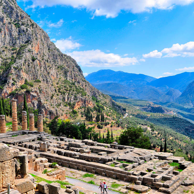 Ancient ruins of Delphi archeological site with stone columns and mountain scenery